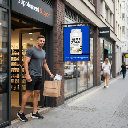 Sportlicher Mann mit Einkaufstasche und Whey Shake vor Geschäft für Nahrungsergänzungsmittel