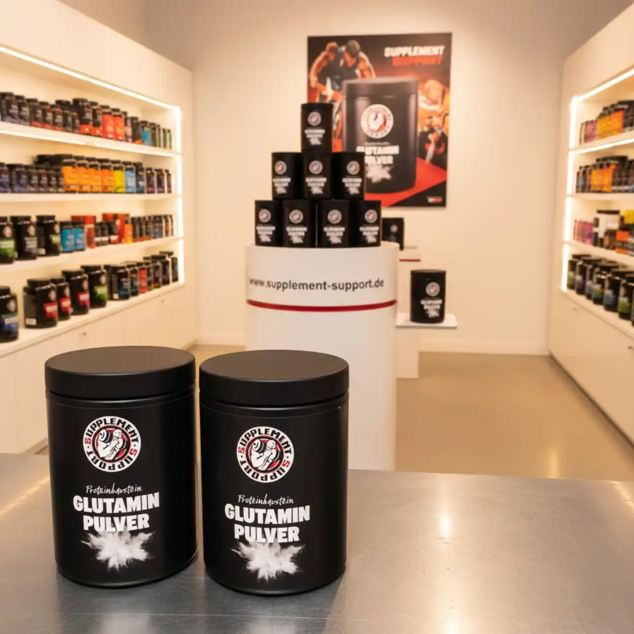 Zwei Dosen Glutamin Pulver im hellen Sportnahrung Shop mit Regalen voller Supplemente