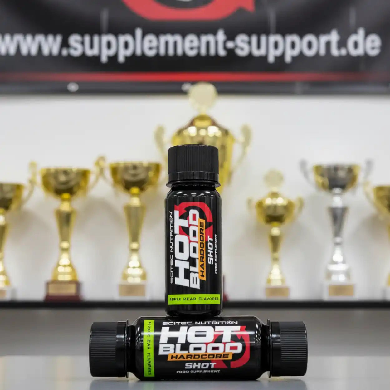 Scitec Nutrition Hot Blood Hardcore Shot vor Pokalen, Nahrungsergänzungsmittel Sportnahrung