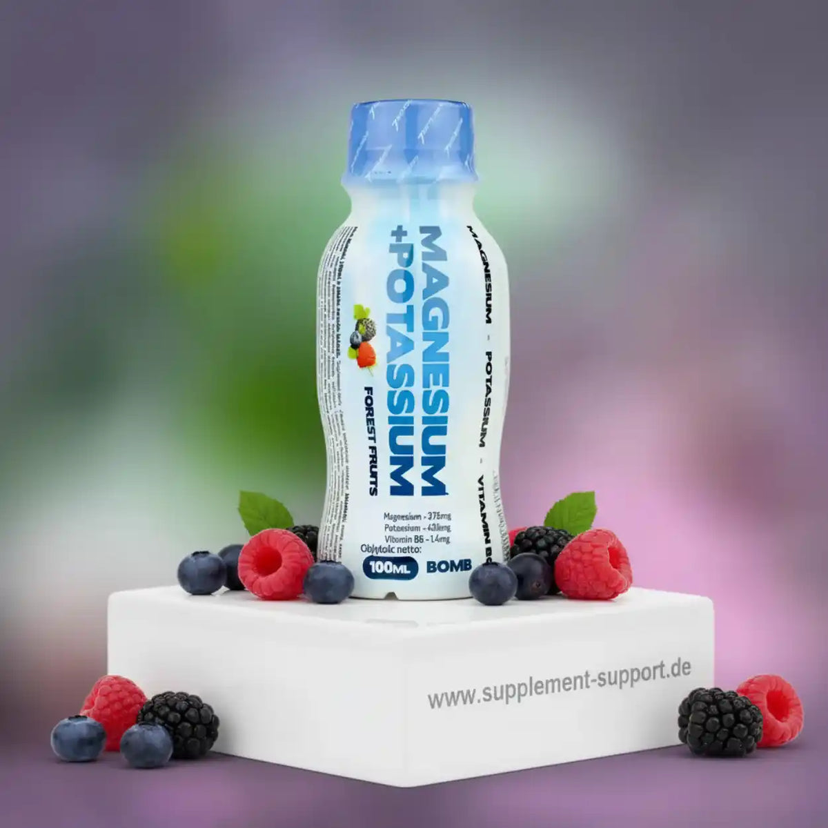 BOMB Magnesium + Potassium Trinkflasche Geschmack Waldfrüchte mit Beeren auf weißem Podest