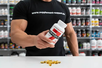 Muskulöser Mann hält Omega-3-Kapseln in Supplement-Shop, Nahrungsergänzungsmittel für Sportler