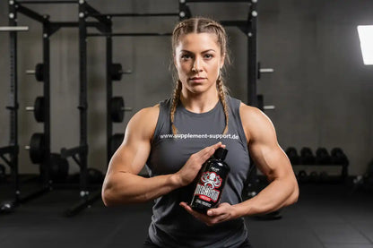 Sportliche Frau im Fitnessstudio hält AK47 Labs Mega Grip Liquid Chalk von Supplement Support