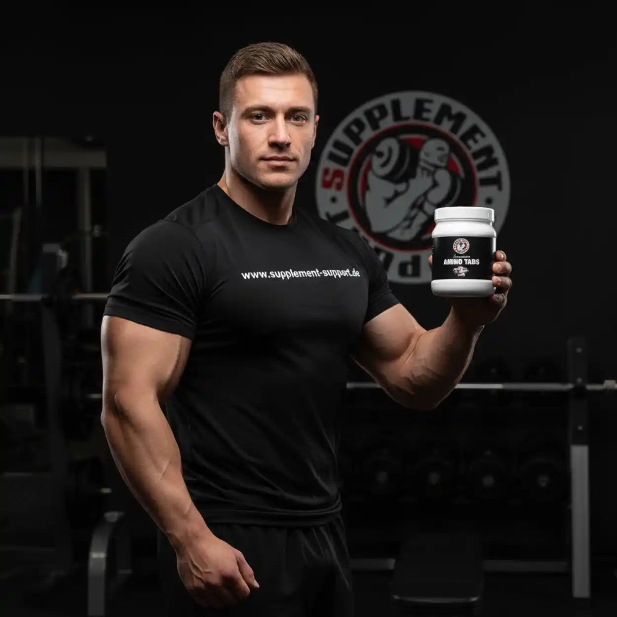 Muskulöser Mann mit Amino Tabs in Fitnessstudio – Protein & Sportnahrung