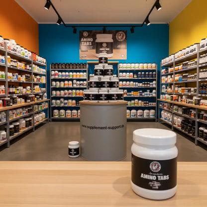 Amino Tabs im Supplement-Shop mit Regalen voller Nahrungsergänzungsmittel und Proteinprodukten