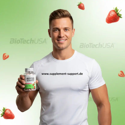 Muskulöser Mann hält Ashwa Candy von BioTechUSA, Nahrungsergänzung mit Erdbeeren, ideal für Sport und Fitness
