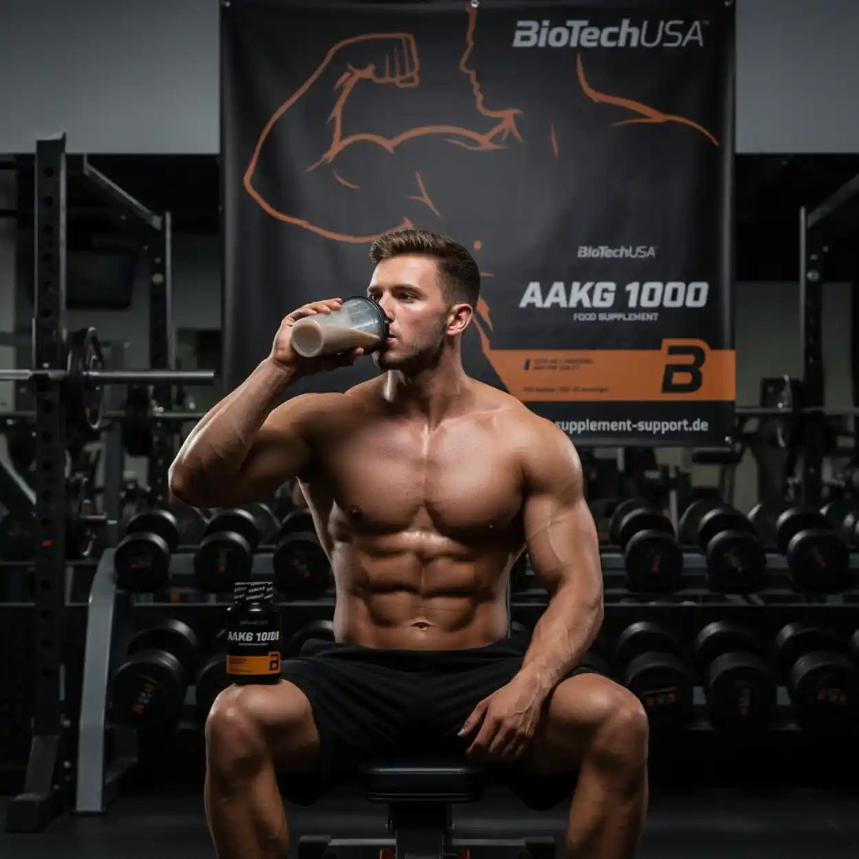 Muskulöser Mann trinkt AAKG 1000 Proteinshake im Fitnessstudio