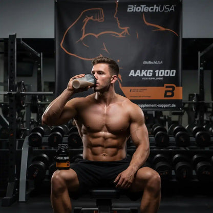 Muskulöser Mann trinkt AAKG 1000 Proteinshake im Fitnessstudio