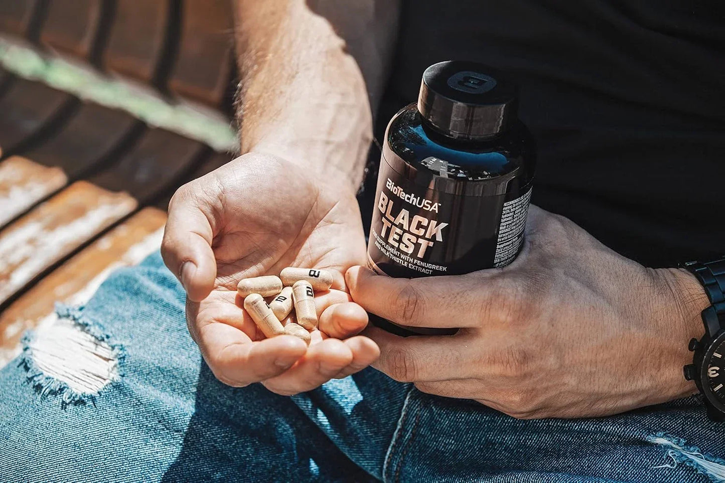 BioTechUSA Black Test Kapseln Dose und Kapseln in Männerhand auf Jeans
