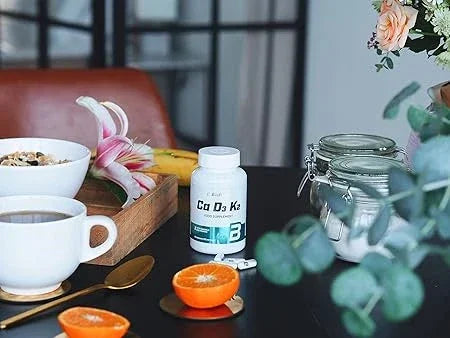 Biotech USA Ca D3 K2 90 Kapseln Supplement auf Frühstückstisch mit Obst und Kaffee