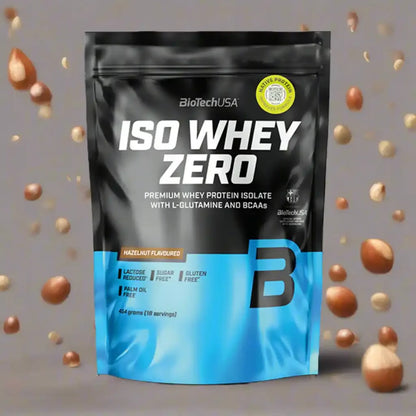 BiotechUSA Iso Whey Zero Proteinpulver Haselnussgeschmack, 454g, auf grauem Hintergrund mit fliegenden Haselnüssen.