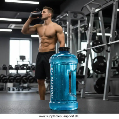 Blauer BiotechUSA Trinkflasche im Fitnessstudio mit muskulösem Mann im Hintergrund