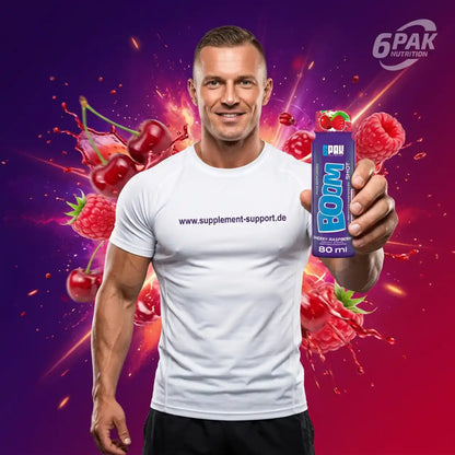 Muskulöser Mann hält einen TREC NUTRITION BOOM Pre Workout Shot mit Kirschen und Himbeeren.