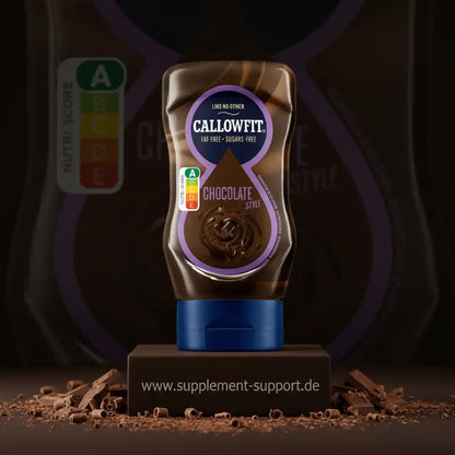 Callowfit Protein-Drink in Schokoladen-Geschmack auf einem Podest mit Schokoladenraspeln.