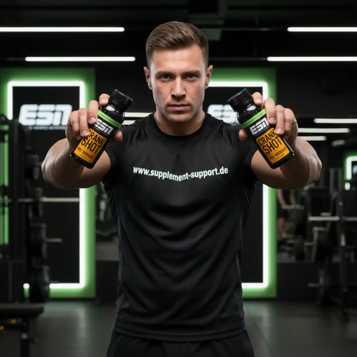 Muskulöser Mann hält ESN Crank Shot Booster in Fitnessstudio, ideal für Sportnahrung und Energie