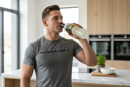 Sportlicher Mann trinkt ESN Hydrorade Sports Drink, trägt Supplement Support Shirt in moderner Küche