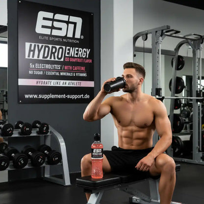 Muskulöser Mann trinkt ESN Hydro Energy in Fitnessstudio, Protein & Booster für Athleten