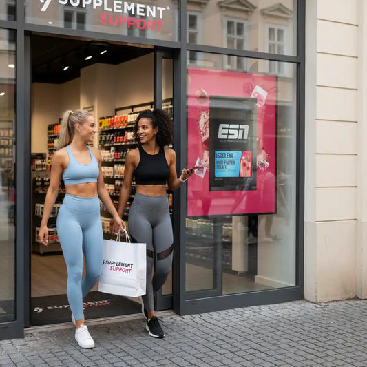 Zwei sportlich gekleidete Frauen verlassen Sportnahrung-Shop mit Einkaufstüte für Nahrungsergänzungsmittel