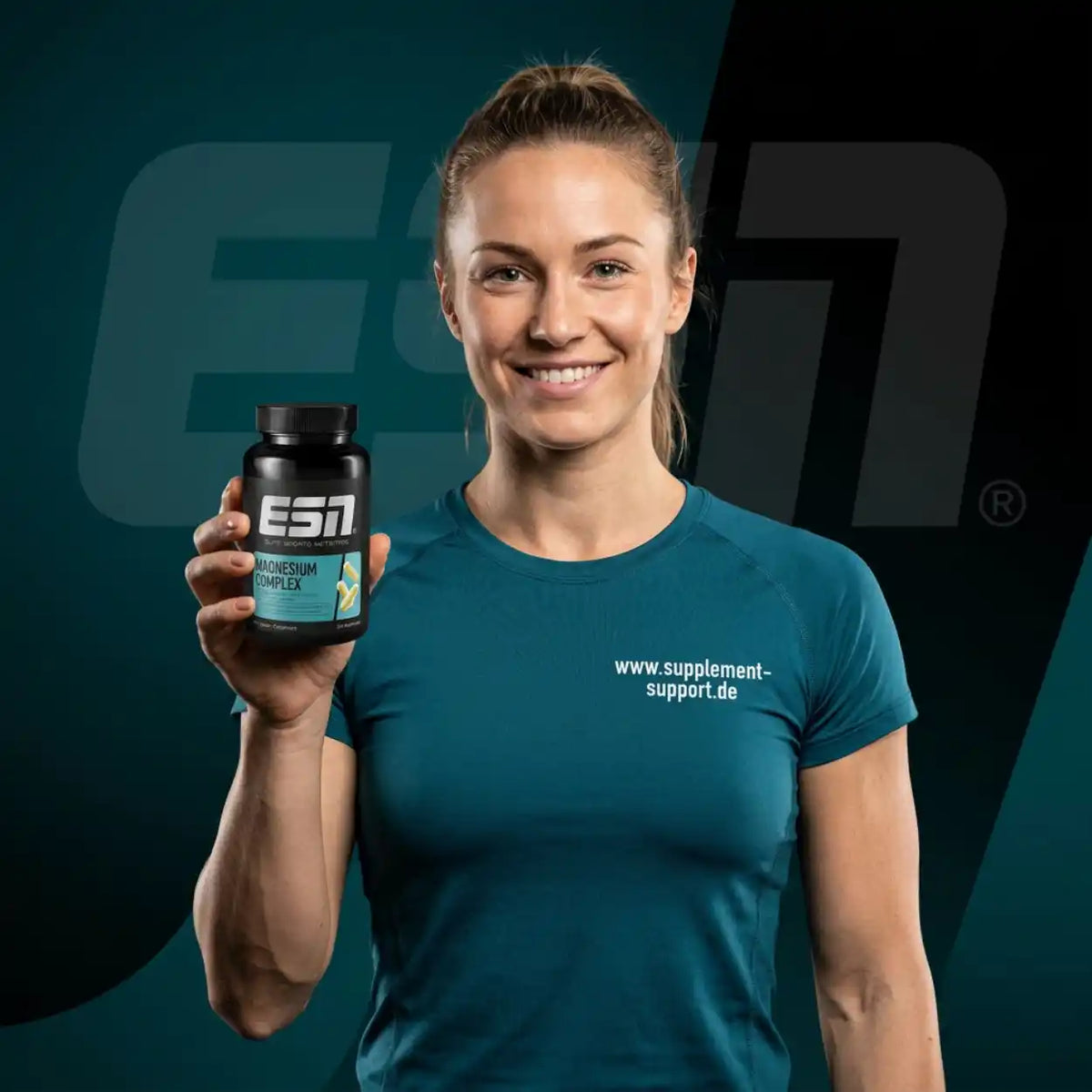Lächelnde Frau in Sportkleidung hält eine Dose ESN Magnesium Complex.