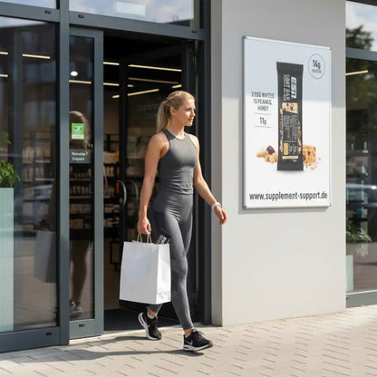 Frau mit Einkaufstüte verlässt Supplement-Store, Proteinriegel-Werbung an der Wand