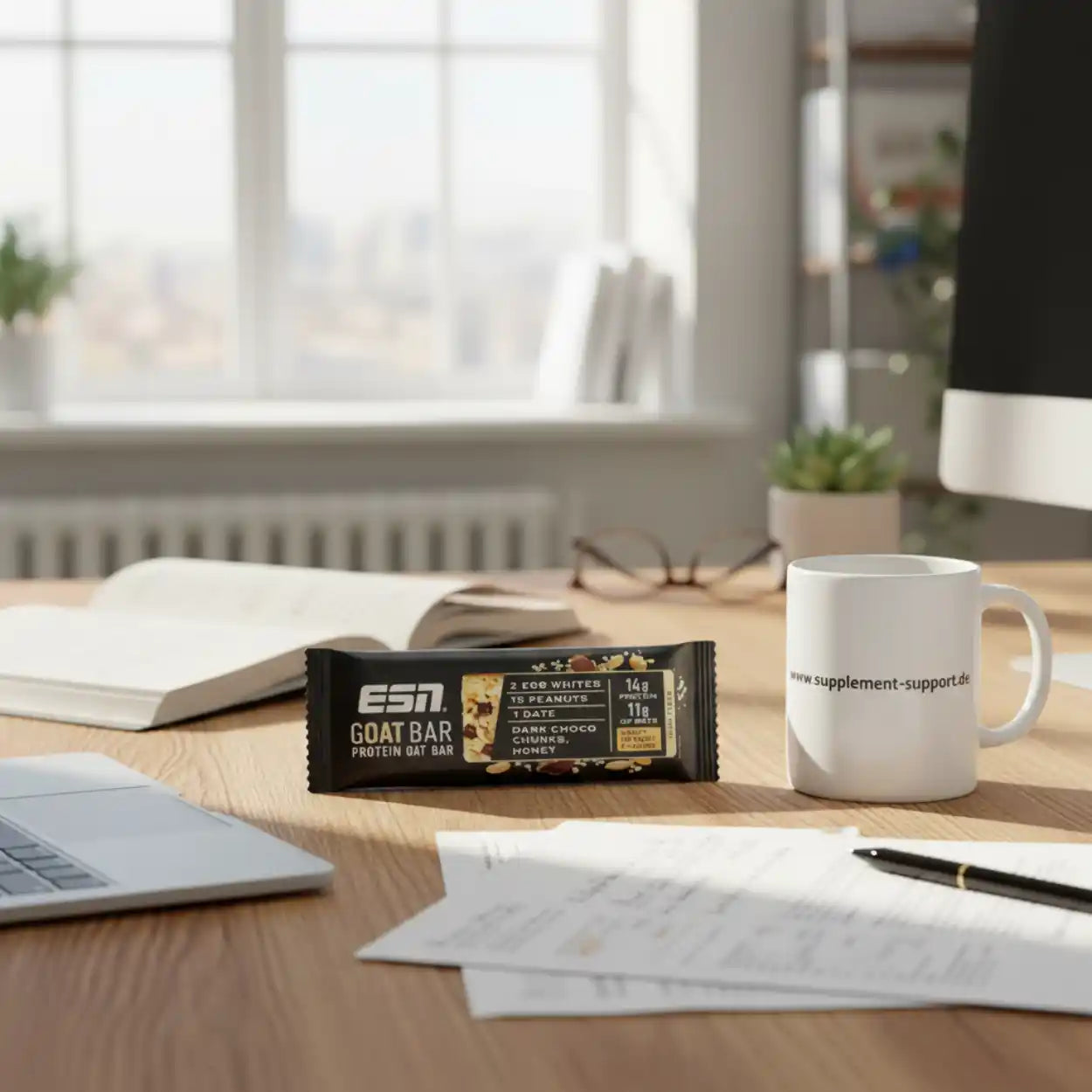 ESN Goat Bar Protein Oat Bar mit Schokolade und Honig auf Schreibtisch neben Tasse und Laptop