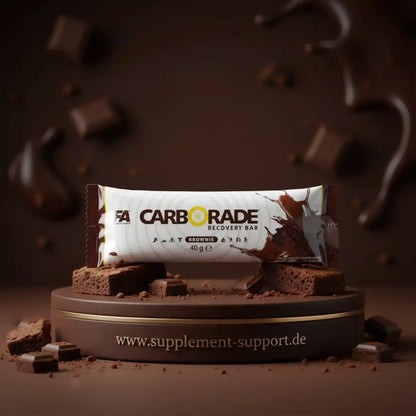 FA Nutrition Carborade Recovery Bar in Brownie-Geschmack auf einem Podest mit Schokoladenstücken.