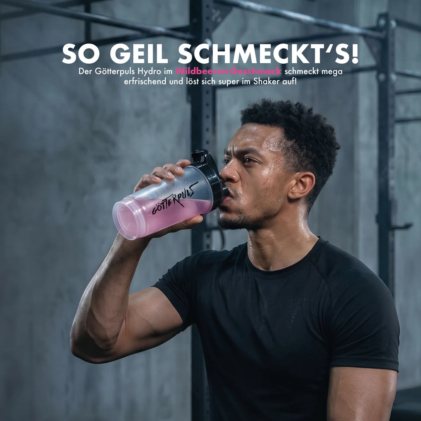 Athlet trinkt pinken Göttpuls Hydro Wildbeeren-Shake aus Shaker im Fitnessstudio