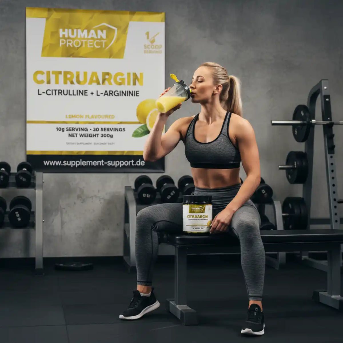 Sportlerin trinkt Zitronen-Supplement Citruargin im Fitnessstudio