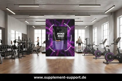 Hyper Mass Protein Gainer in Fitnessstudio mit Trainierenden und Trainingsgeräten