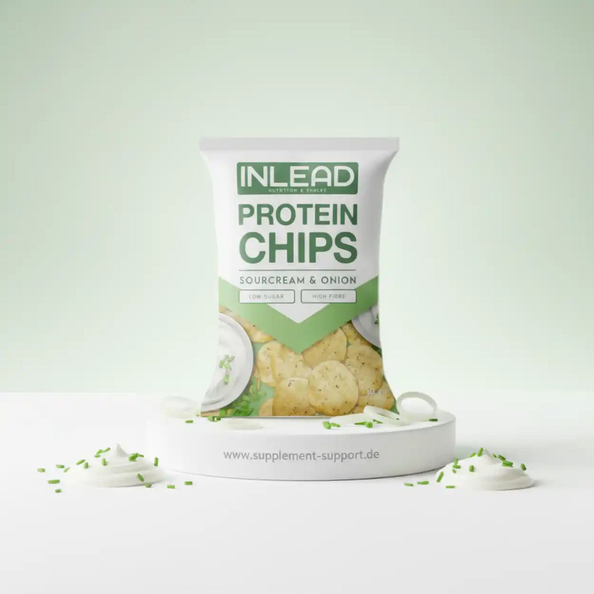 Inlead Protein Chips Sourcream & Onion auf weißem Podest mit Dip und Schnittlauch