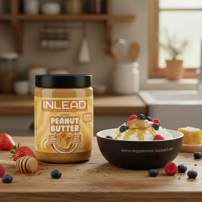 Peanut Butter Streichcreme mit Honig im Glas neben Schüssel mit Quark, Beeren und Honig