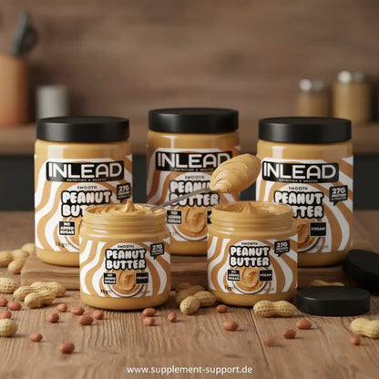 Mehrere Gläser proteinreiche Erdnussbutter auf Holztisch, mit Erdnüssen dekoriert