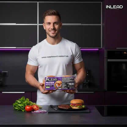 Muskulöser Mann hält INLEAD Protein Burger Buns in moderner Küche mit frischem Burger und Zutaten