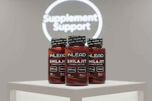 Drei INLEAD Shilajit Kapselgläser mit Vitamin C, B6 & B12 auf weißem Podest, Supplement Support Logo im Hintergrund.