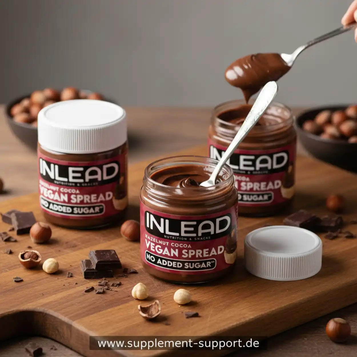Drei Gläser vegane Haselnuss-Kakao-Creme ohne Zuckerzusatz auf Holzbrett, Nüsse und Schokolade daneben.