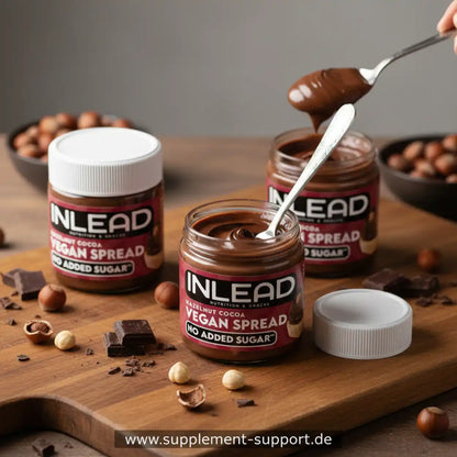 Drei Gläser vegane Haselnuss-Kakao-Creme ohne Zuckerzusatz auf Holzbrett, Nüsse und Schokolade daneben.