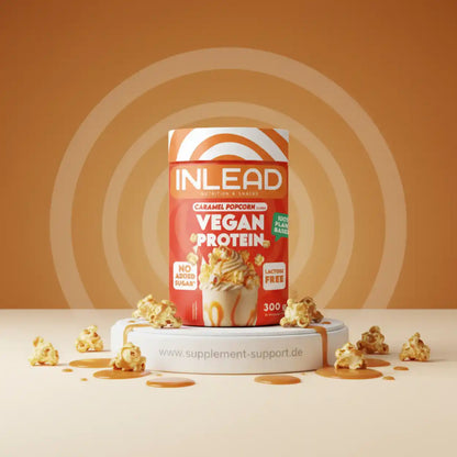Inlead Vegan Protein Powder im Geschmack Caramel Popcorn auf weißem Podest mit Popcorn.