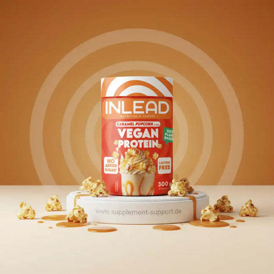 Inlead Vegan Protein Powder im Geschmack Caramel Popcorn auf weißem Podest mit Popcorn.