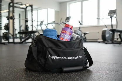 Schwarze Sporttasche mit D3+K2-Vitaminen und Trinkflasche im Fitnessstudio, supplement-support.de