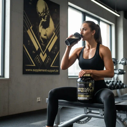 Frau trinkt Proteinshake im Fitnessstudio mit Anabolic IsoWhey