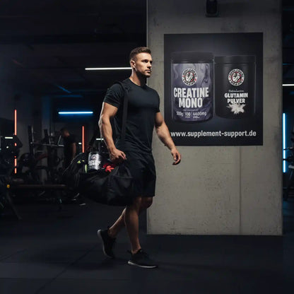 Muskulöser Mann mit Sporttasche im Fitnessstudio vor Werbung für Creatine Mono und Glutamin Pulver