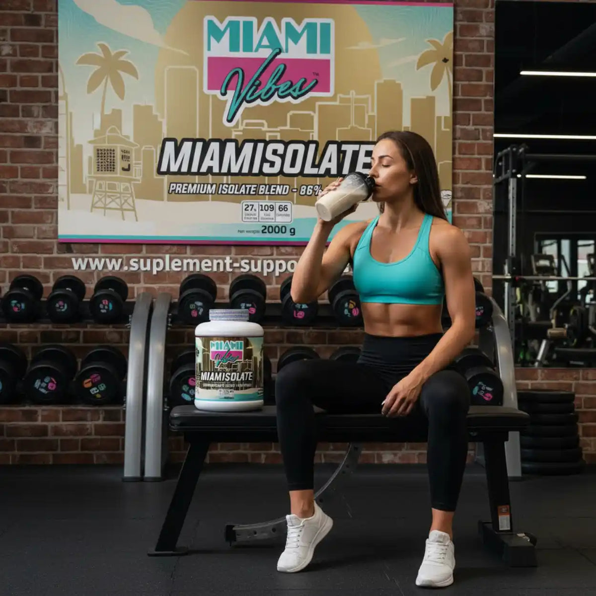Muskulöse Frau trinkt Proteinshake neben einer Packung MIAMI VIBES MIAMISOLATE im Fitnessstudio.