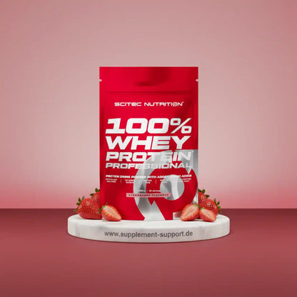 100% Whey Protein Professional von Scitec Nutrition, Erdbeer-Geschmack, umgeben von frischen Erdbeeren auf weißem Podest