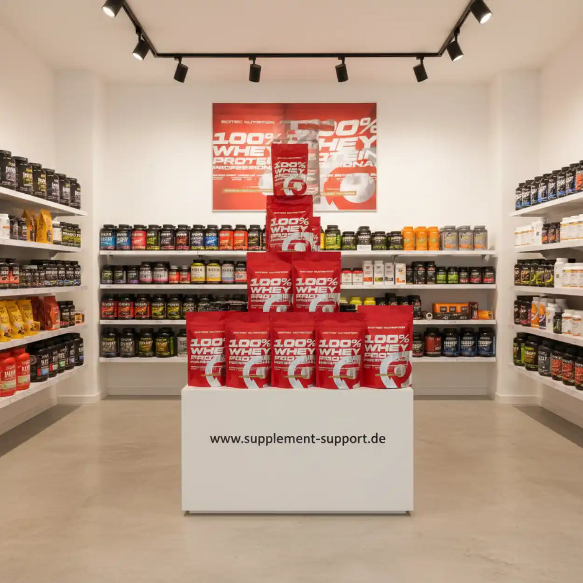 100% Whey Protein in roten Beuteln im Supplement-Shop, Regale mit Nahrungsergänzungsmitteln im Hintergrund
