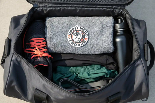 Geöffnete Sporttasche mit Handtuch, Sportschuh, Trinkflasche und Trainingskleidung