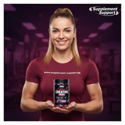 Frau hält Micronized Creatine Gummies von WEIDER in Fitnessstudio, ideal für Sportnahrung und Muskelaufbau