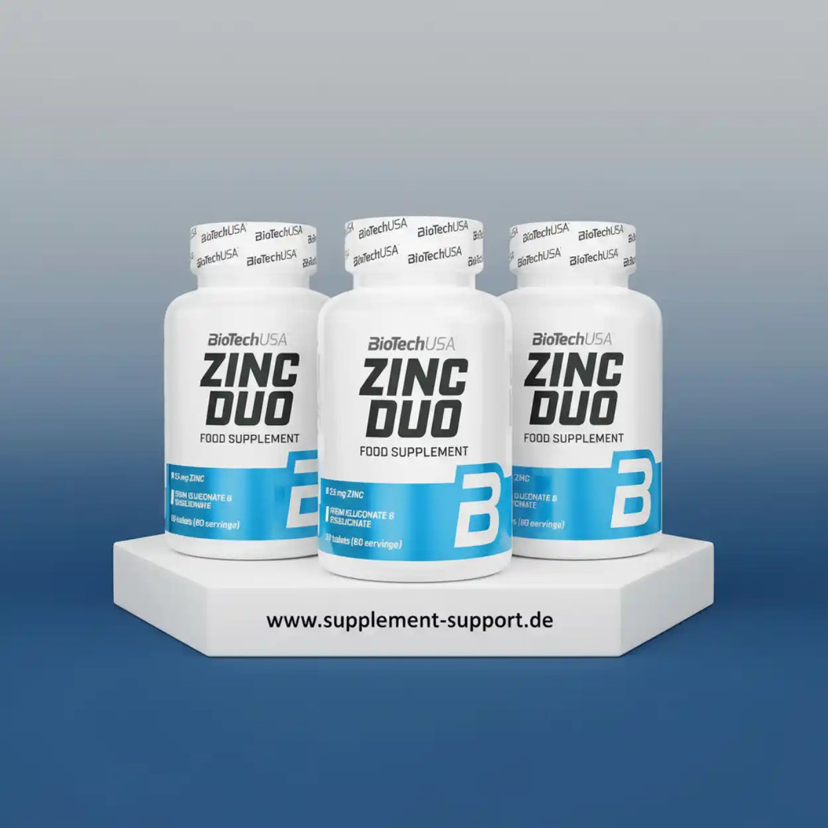 Drei weiße Dosen BioTechUSA Zinc Duo Nahrungsergänzungsmittel auf einem weißen Podest.